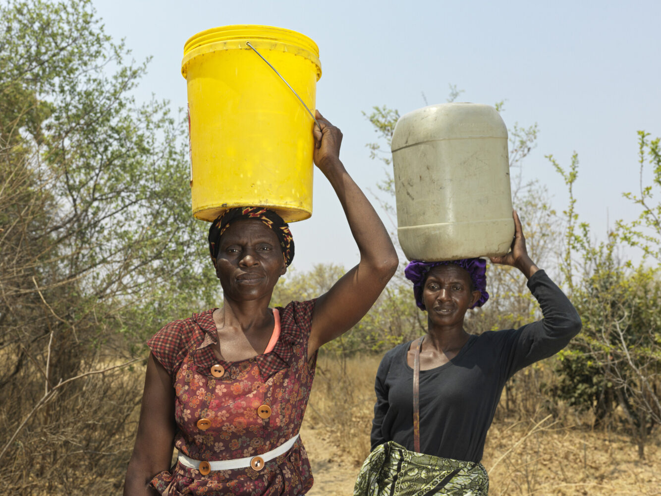 Deux femmes portent des seau d'eau