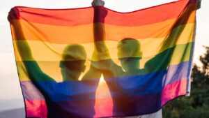 Deux personnes tiennent le drapeau des fiertés