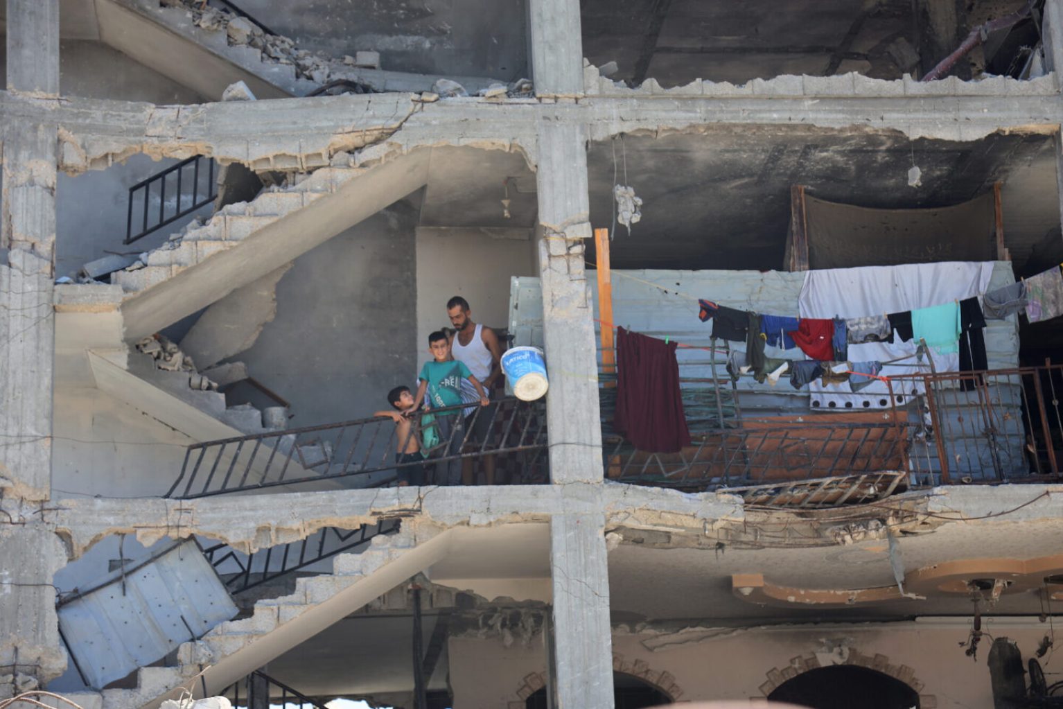 Une famille dans les décombres d'un immeuble bombardé à Gaza