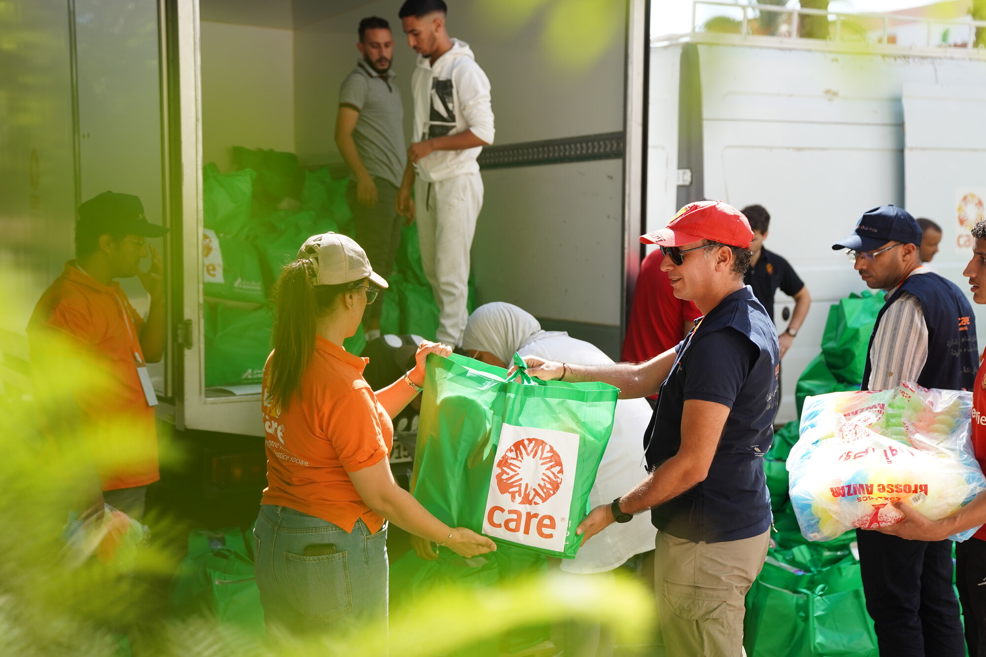 Deux membres de l'ONG CARE tiennent un sac de distribution d'aide humanitaire entre leurs mains