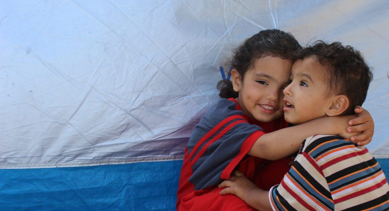 Deux enfants se prennent dans les bras en Syrie.