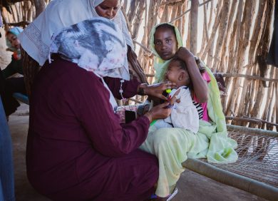 Une femme soigne un bébé réfugiée par le conflit au Soudan dans un camp au Tchad.