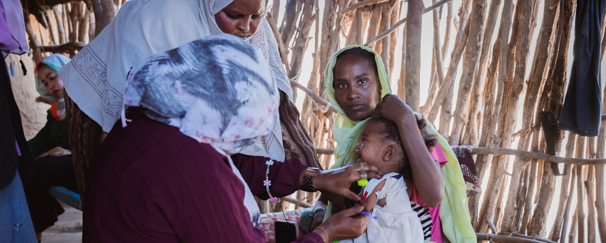 Une femme soigne un bébé réfugiée par le conflit au Soudan dans un camp au Tchad.