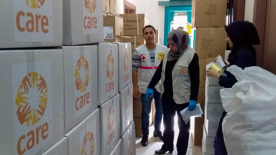 Des membres de l'ONG CARE devant des colis de nourriture en Palestine