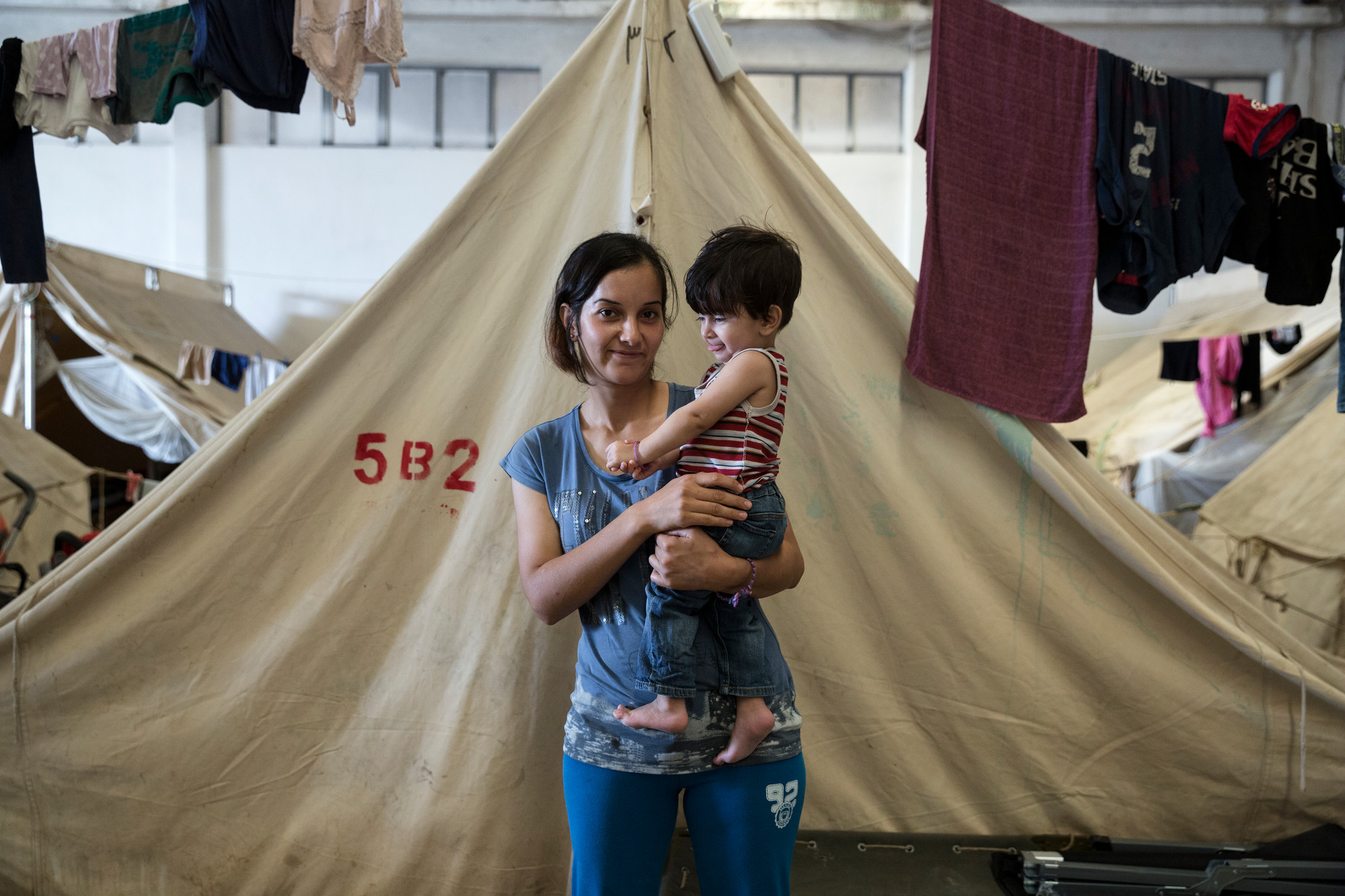 une femme et son enfant réfugiés devant une tente