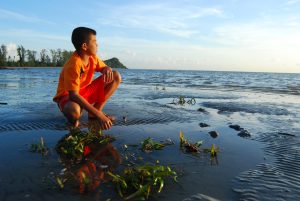 Une garçon au bord de l'eau au Vietnam