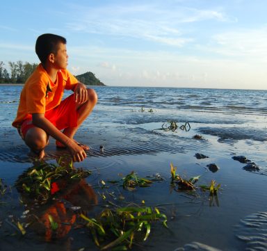 Une garçon au bord de l'eau au Vietnam