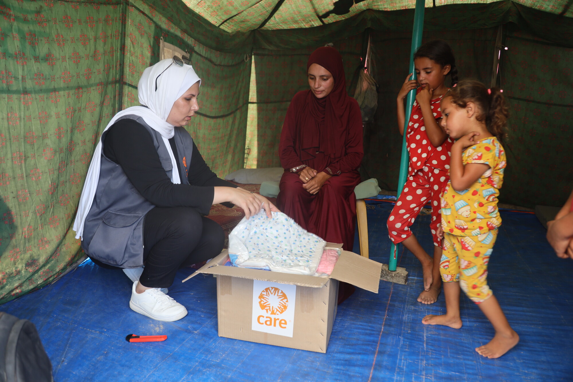 Une membre de l'ONG humanitaire CARE distribue des vivres à une famille victime de la guerre à Gaza