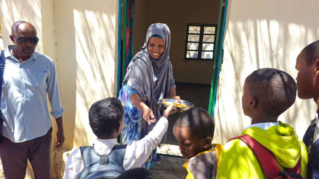 Une bénévole de l'ONG CARE distribue des repas aux enfants dans une école au Somaliland
