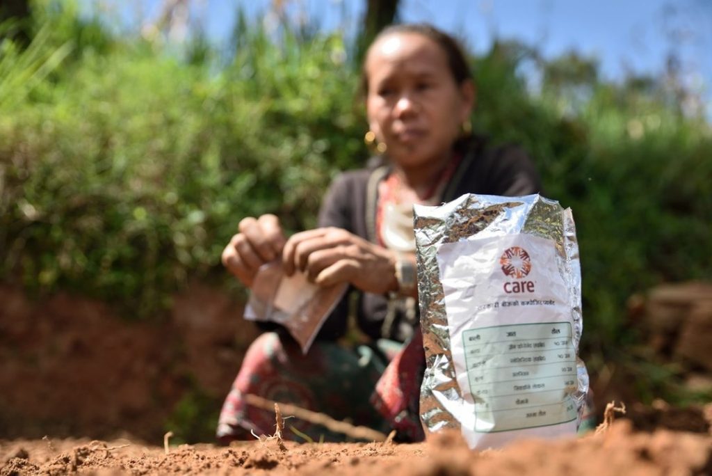 Une femme népalaise plante des graines fournies par CARE.
