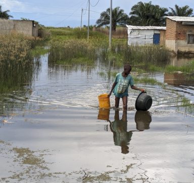 Un garçon marche dans les eaux inondées du village de Gatumba.