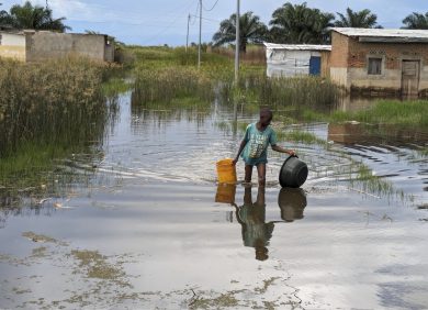 Un garçon marche dans les eaux inondées du village de Gatumba.