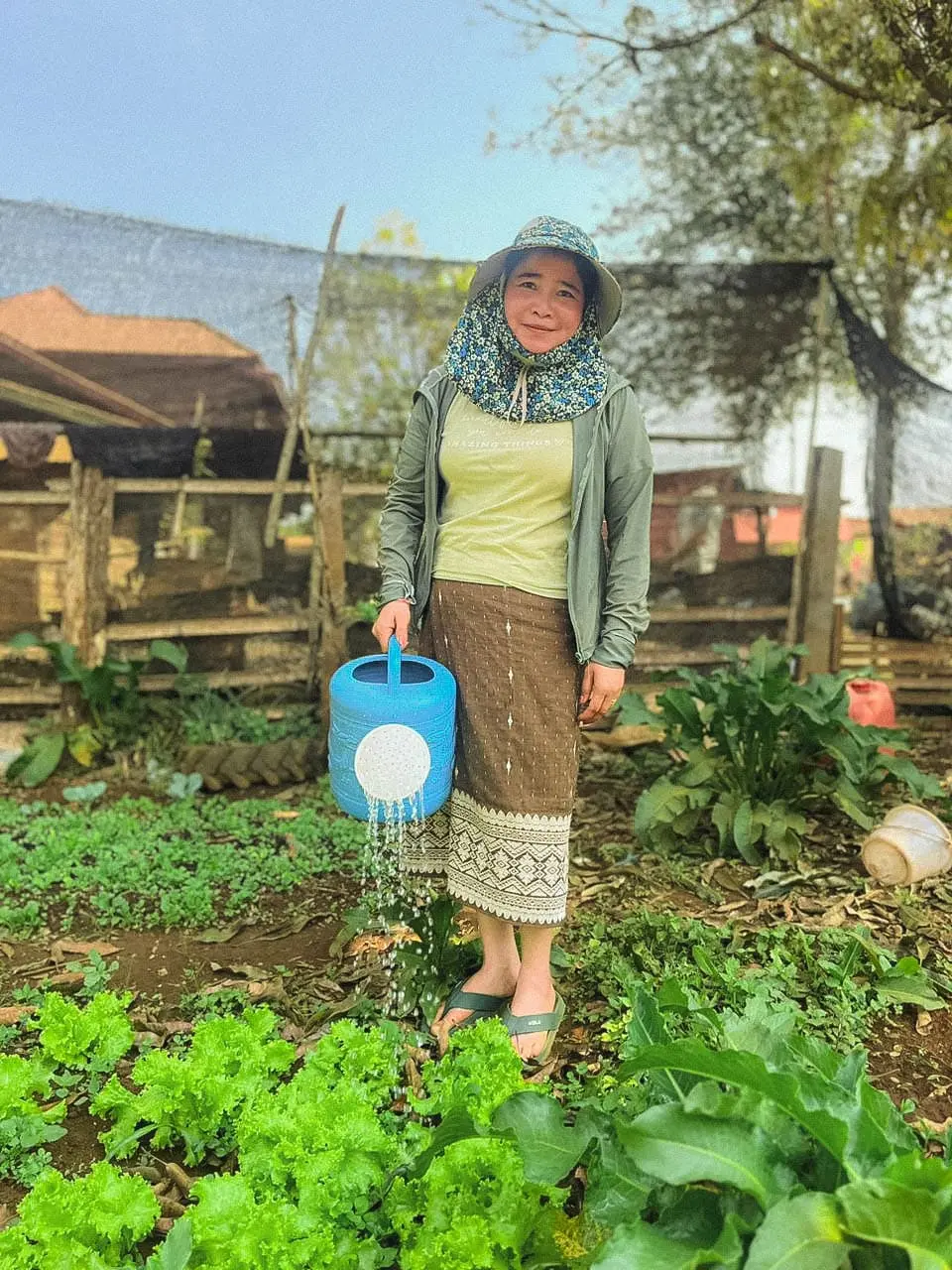 Une agricultrice au Laos arrose sa terre