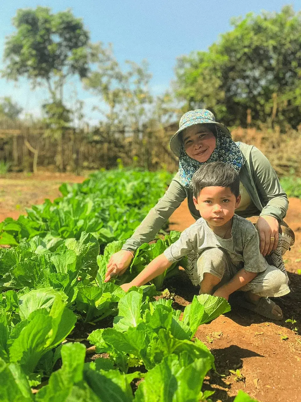 Une femme et son fils dans leur jardin potager