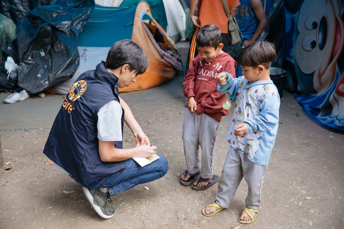 Un membre de l'ONG CARE avec deux enfants qui ont fui le Venezuela