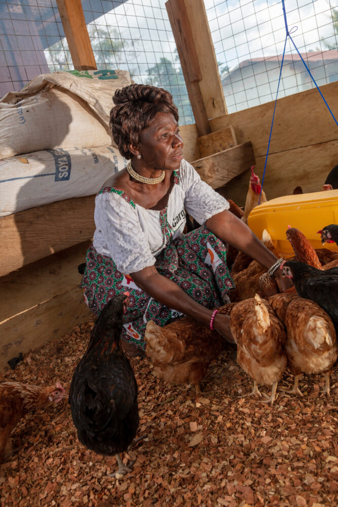 Une femme entrepreneure avec ses poules. Elle est soutenue par CARE