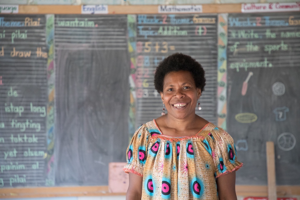 Enseignante devant son tableau soutenue par CARE en Papouasie-Nouvelle-Guinée